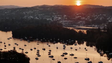 High aerial approach over Windermere Lake and village at sunrise