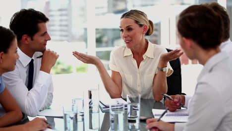 businesswoman gesturing in front of colleagues