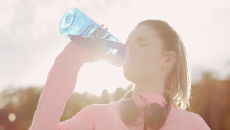 vista de mano de una mujer bebiendo agua después de un entrenamiento duro