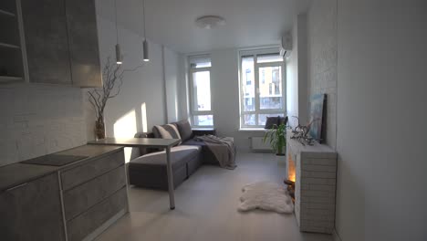 Modern-minimalistic-dark-gray-loft-style-studio-apartment-interior-design.-kitchen,-sitting-area,-workplace