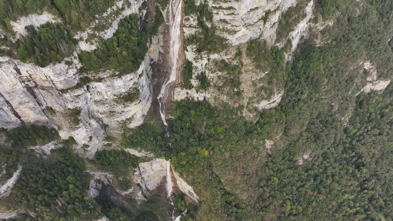 Drone view of the cascade system of three Seerenbachfälle waterfalls in Switzerland. Rocky nature with forests