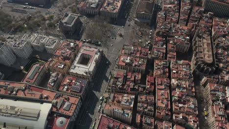 Traffic-in-streets-and-square-surrounded-by-historical-buildings.-High-angle-view-of-urban-borough.-Barcelona,-Spain