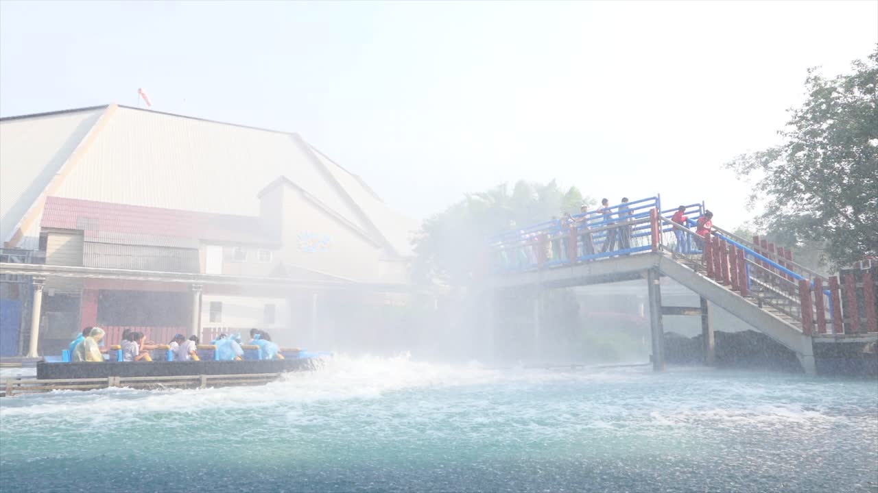 slowmo: 사람들이 어트랙션 파크 꿈의 세계에서 미끄럼틀을 타고 다리에서 사람들에게 물을 튀기는 보트