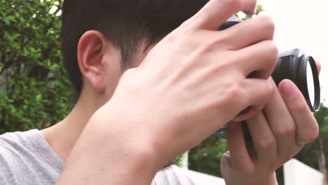 orbit circle shot of young male photographer taking photos in nature scenery