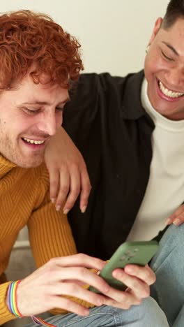 two happy men sharing a moment looking at a smartphone