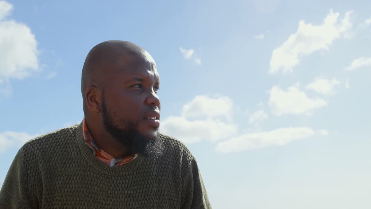 hombre pensativo sentado en un banco en el paseo marítimo 4k