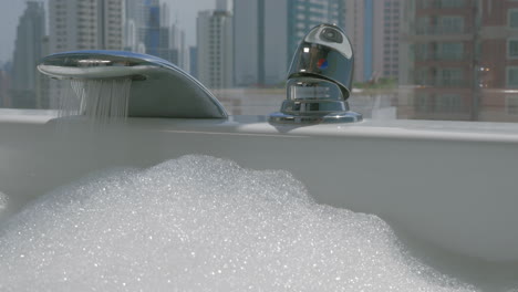 Woman-pouring-water-into-the-bathtub-with-foam