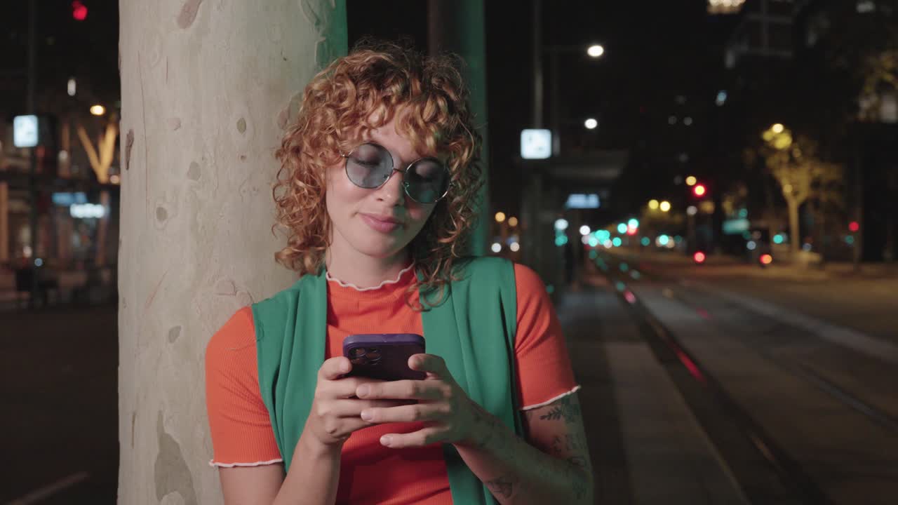 Donna che utilizza il telefono cellulare di notte