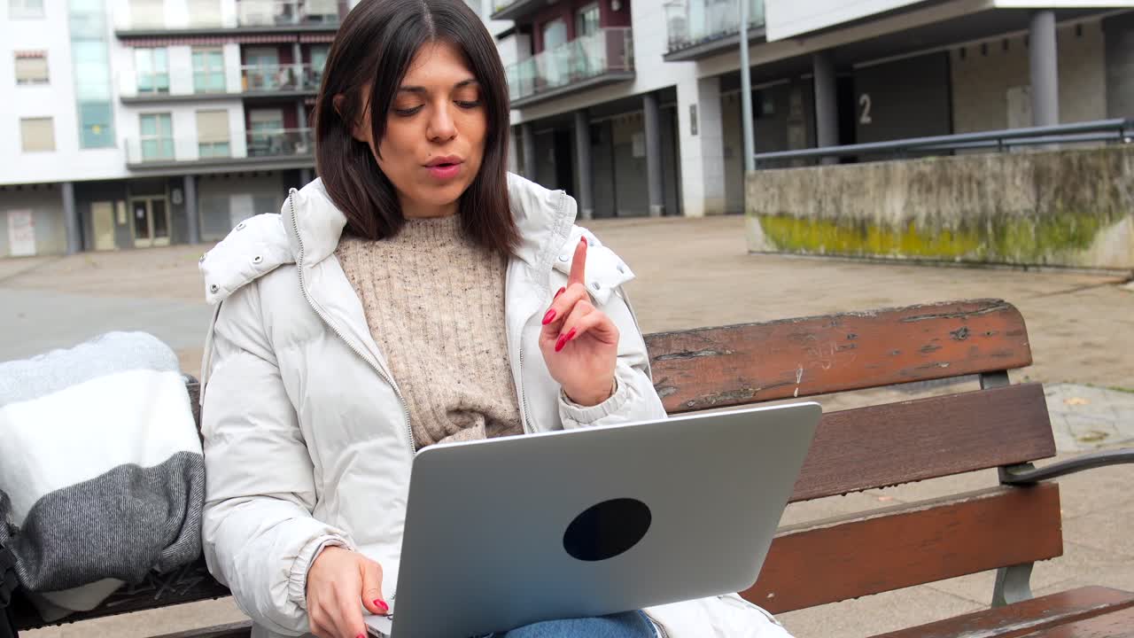 Mujer trabajando en un portátil en un parque urbano