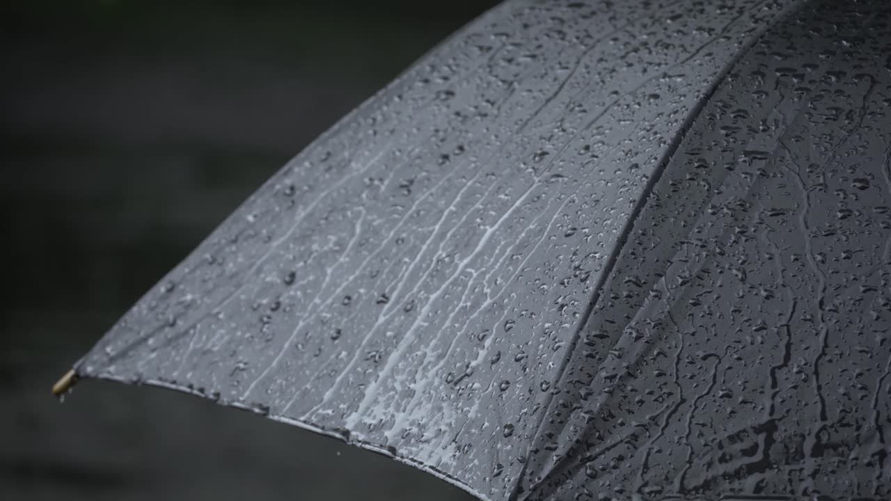 sort paraply bliver våd i regnen