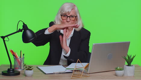 tired serious upset senior businesswoman showing time out gesture, limit or stop sign, no pressure