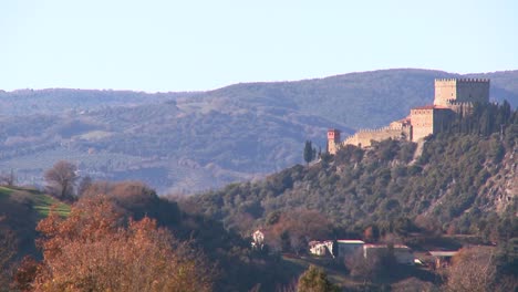una toma amplia de la campiña italiana con un castillo distante que agrega misterio