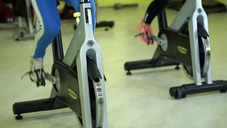 people exercising on stationary bikes in a gym
