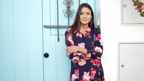 mujer en vestido floral por una puerta azul