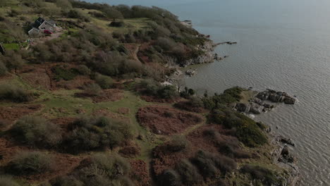 Flying-over-rugged-winter-English-coastline-to-reveal-secluded-gravel-beach-at-Jenny-Brown's-Point-Silverdale-UK