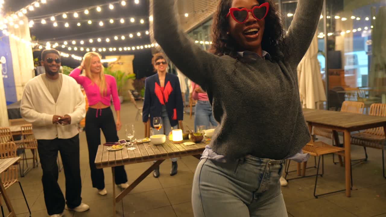 Gruppe af mennesker, der danser og fester udendørs om natten