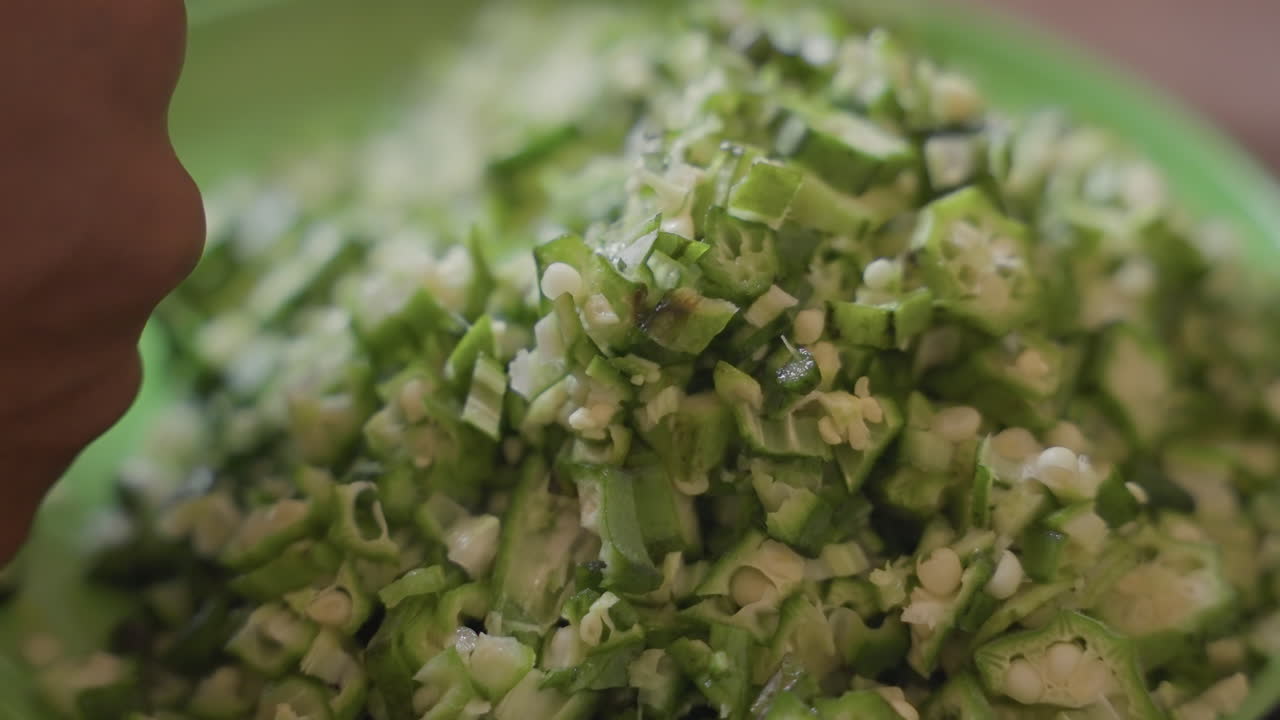 Home chef preparing textured vegetable mixture. Rustic kitchen scene with vibrant leafy vegetable display. Closeup of freshly diced herbs and greens on rustic countertop in warm ambient light
