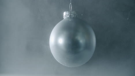 a silver xmas bauble spinning in an dusty environment