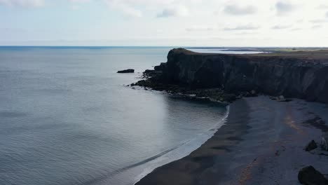 en la costa de islandia con una mujer caminando a
