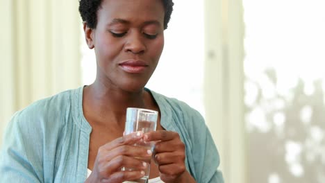 pregnant woman taking a vitamin tablet