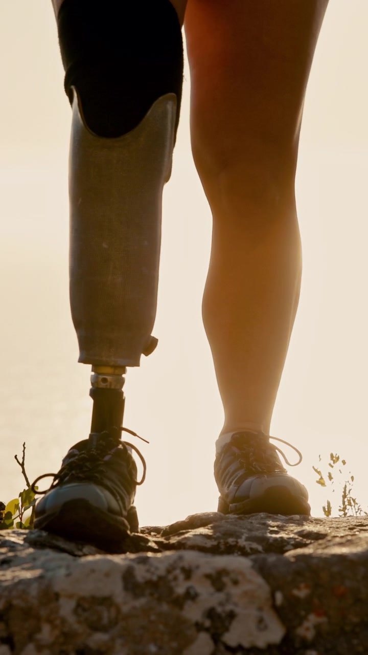 Person with Prosthetic Leg Hiking on Rocky Terrain at Sunset