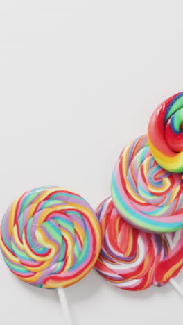 video of rows multicoloured lollipops on white background