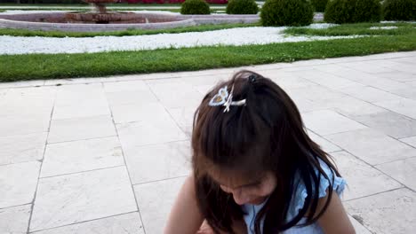 cámara lenta: la niña intenta caminar divertida en el jardín o en el parque