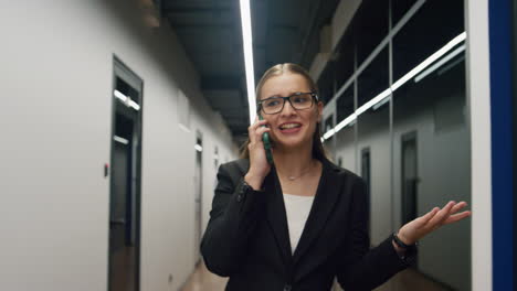 Feliz-Ejecutivo-Hablando-Por-Teléfono-Móvil.-Exitosa-Empresaria-Caminando-Por-El-Pasillo