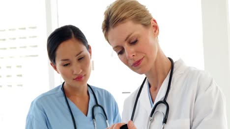 two doctors looking over a file and smiling at camera