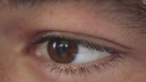 primer plano de la apertura del ojo del hombre reflexión en el iris marrón