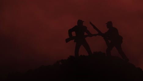 two toy soldier silhouettes in a close battle