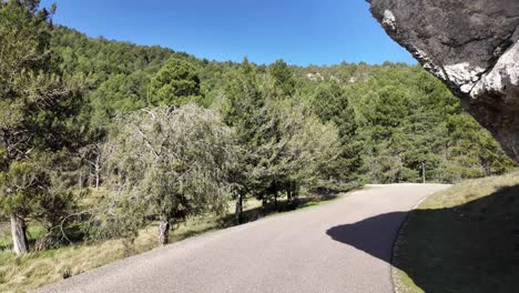 POV-driving-along-a-narrow-mountain-road-with-a-massive-rock-ahead