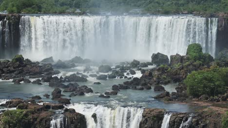 rocky plunge pool eroding from rough crashing waterfall, wide aggressive waterfalls hitting rocks flowing in beautiful rainforest hidden in the jungle in iguazu falls, brazil, south america