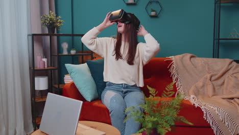 Young-woman-use-virtual-reality-headset-glasses-at-home,-enjoying-video-concept-moving-hands-in-air