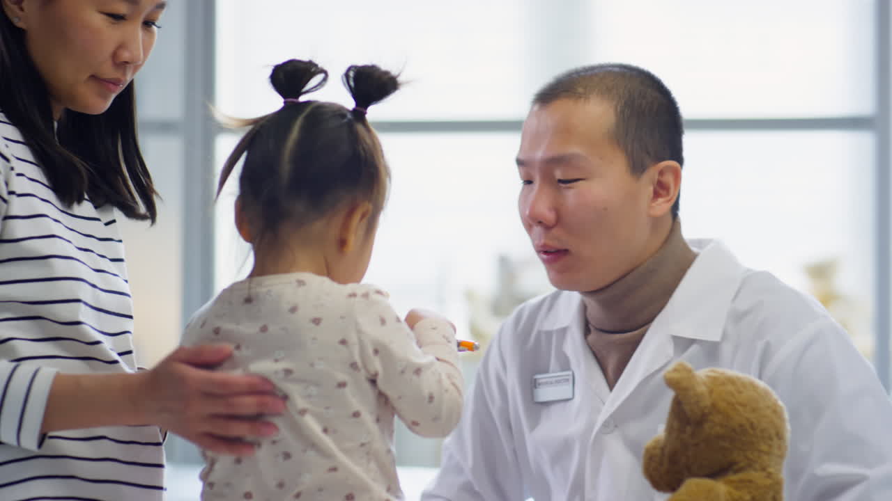 Asian Pediatrician Examining Throat of Little Patient