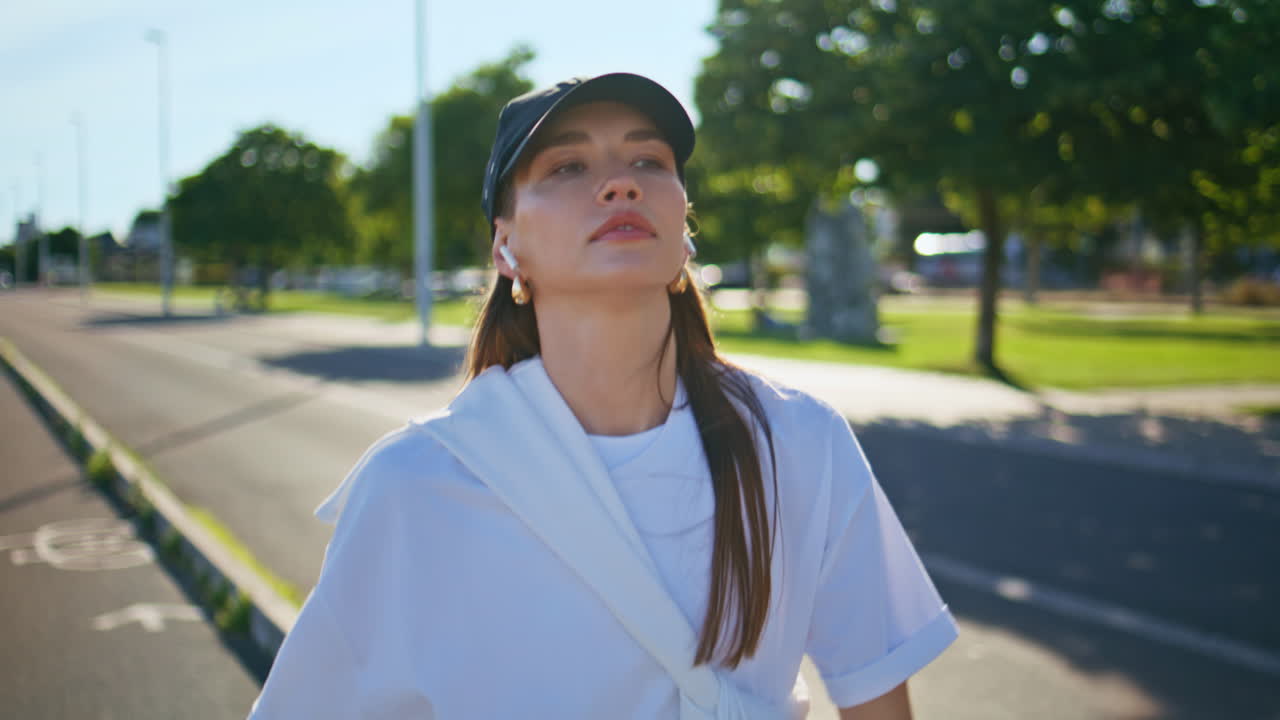 Motivated girl running pathway wearing wireless earbuds closeup. Active runner