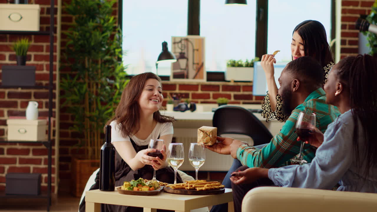 BIPOC friends throwing surprise birthday party for woman, giving her thoughtful gift in living room