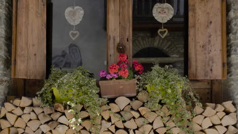 A-beautiful-wooden-window-with-a-fresh-Bouquet-in-Typical-Alpine-houses-in-Rhêmes-Notre-Dame-in-the-Aosta-Valley,-Itally