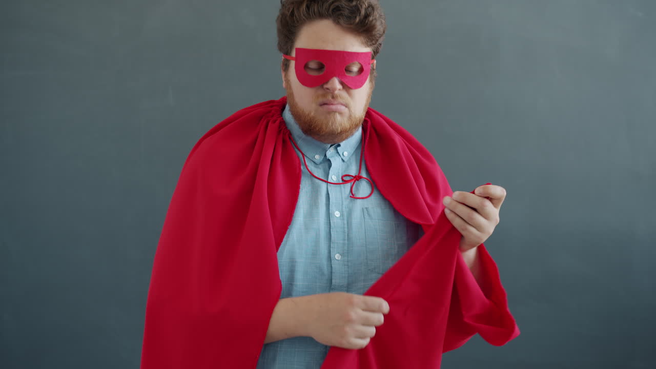 Superhero adjusting his mask and cape