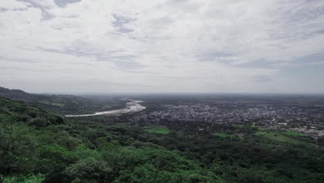 aerial zoom in shot of yopal city, colombia, showing the urban landscape with cloudy sky in the background