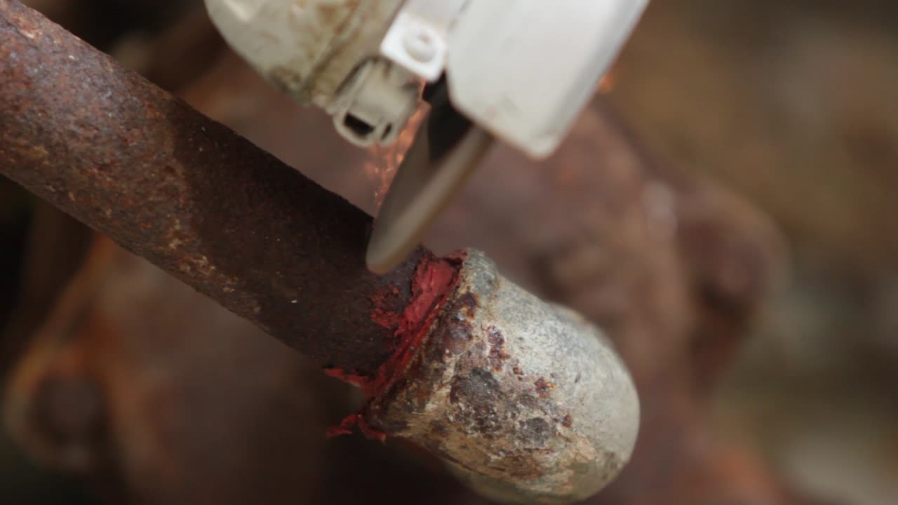 Frontal view of a portable grinding machine, rusty metal pipe cutting, trim, bright sparks
