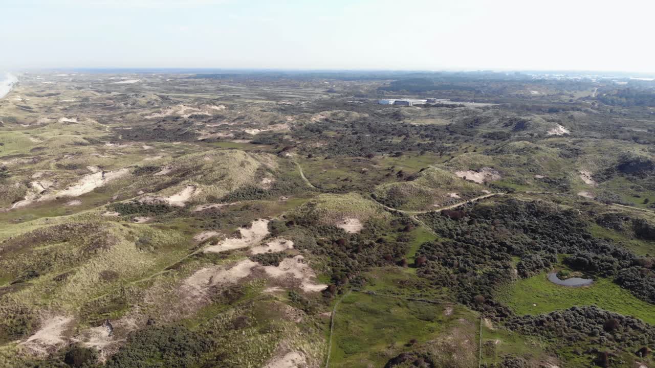 tierras bajas costeras con pequeñas colinas yermas en wijk aan zee, holanda del norte, países bajos - toma aérea sobrevuelo