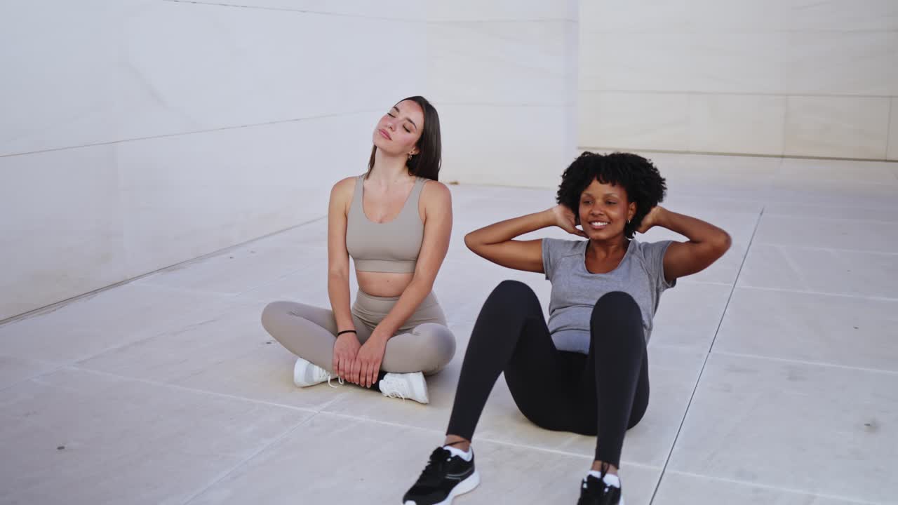 Two Women Doing Sit-ups and Stretching Outdoors