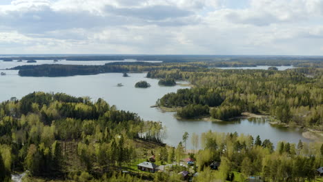 aerial view of a cabins on islands at the gulf of finland, on a partly sunny, spring day, in the porvoo archipelago, in uusimaa - pan, drone shot