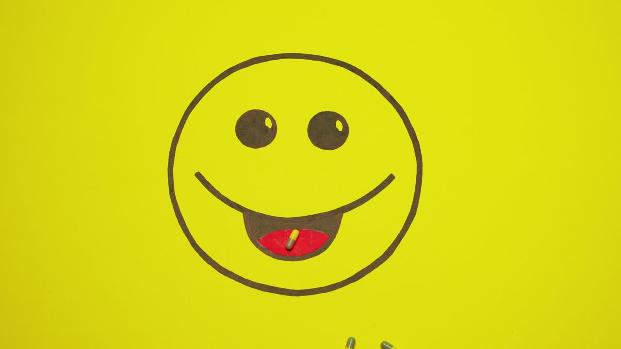 una sonrisa pintada sobre un fondo amarillo. las pastillas se mueven hacia la boca de la sonrisa.