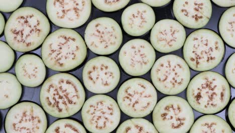 eggplant slices on black. top view. loop motion. rotation 360.