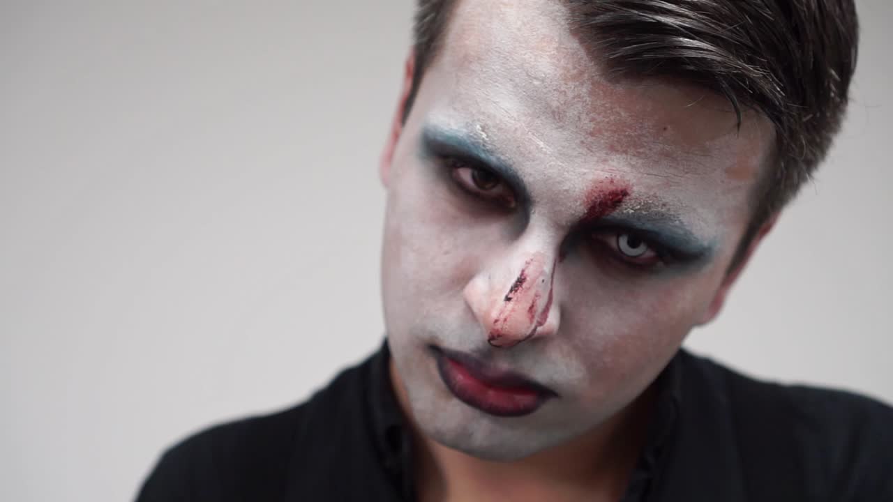 primer plano de detalle del hombre con pintura facial y lentes de contacto en el ojo