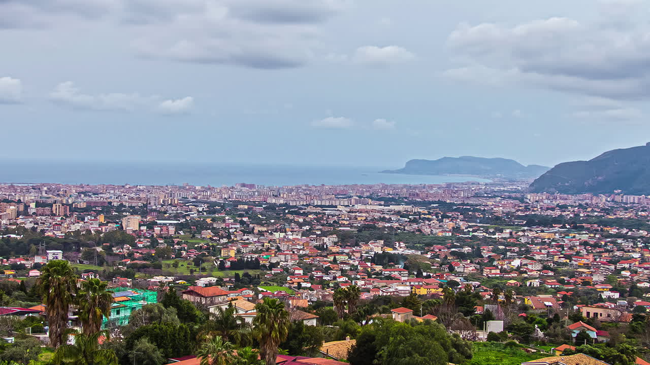 un paisaje urbano de una aldea suburbana cerca de una ciudad en la costa con montañas