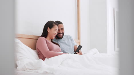 Home-bed,-cellphone-and-happy-couple-laugh