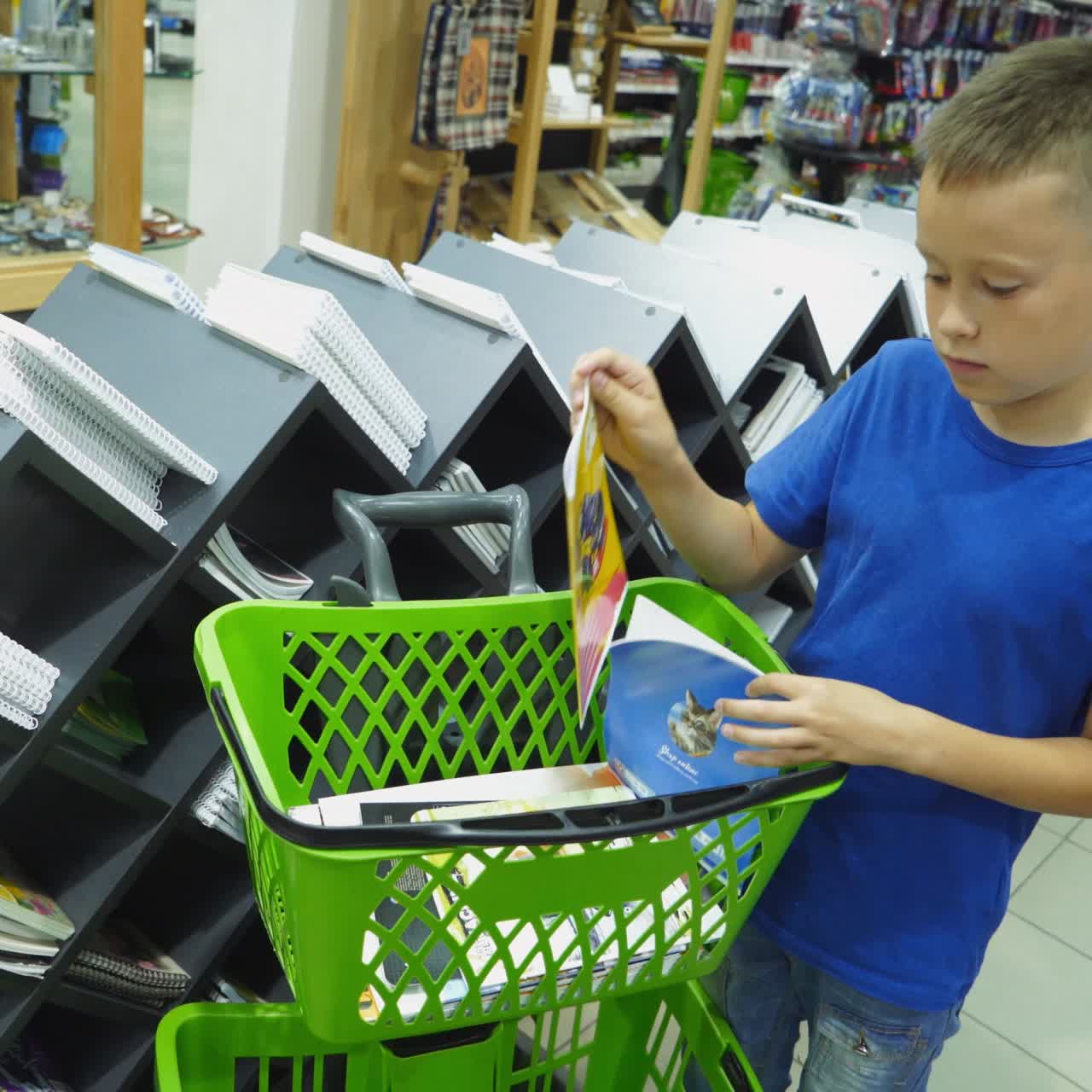 VINNITSA, UKRAINE - AUGUST 20, 2018: Shopping for school. Boy buying different products in stationery shop.